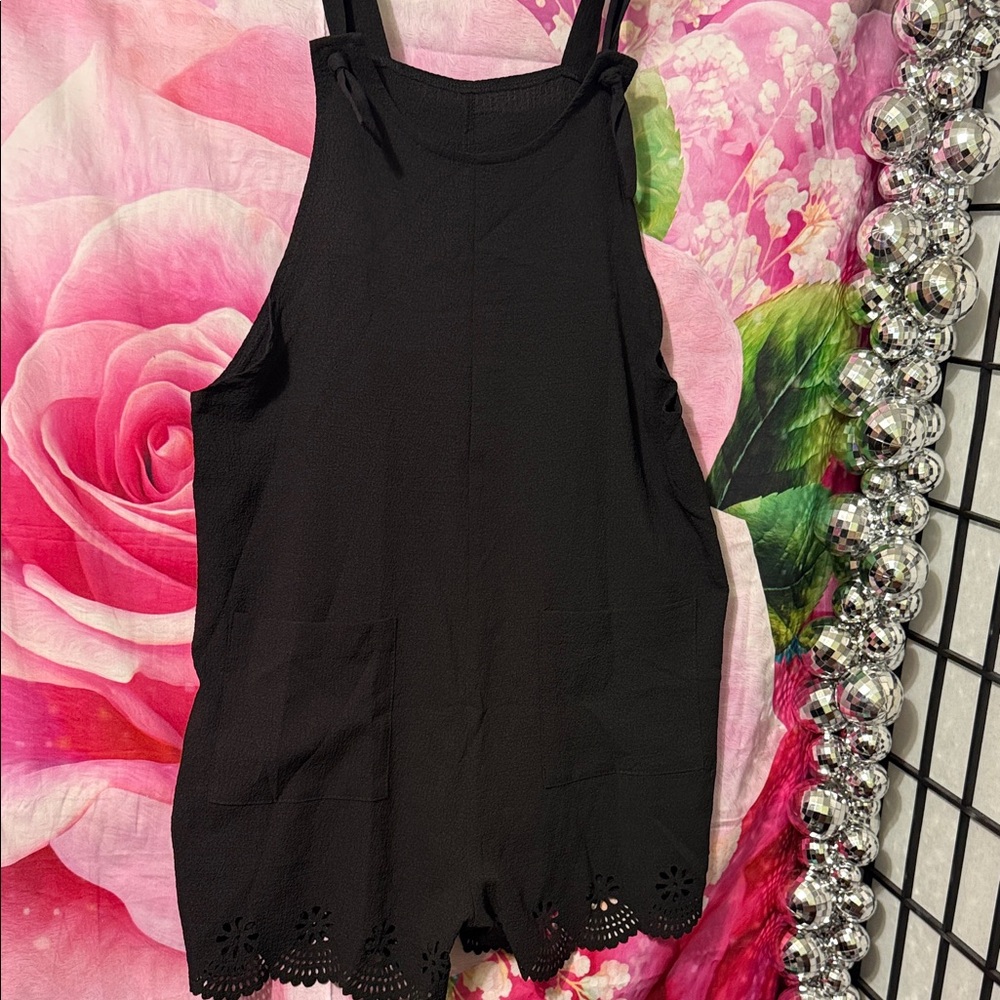 Sleeveless Romper w/laser cut hem at legs. 
2 pockets in front.